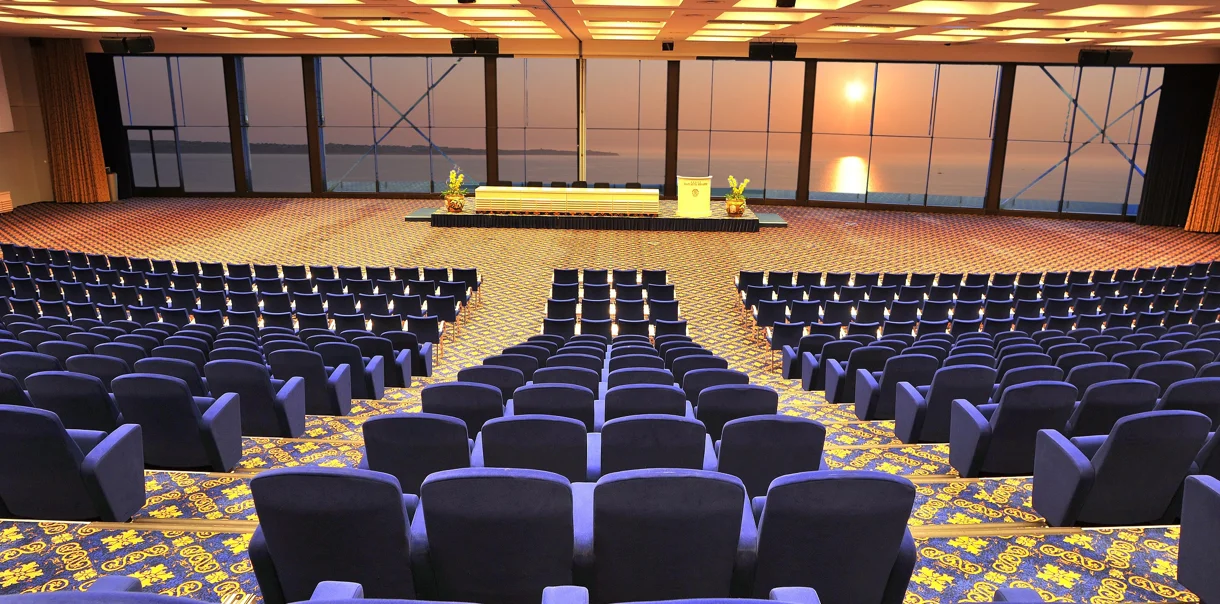 Velika konferenčna dvorana z modrimi sedišči za poslovna srečanja in kongrese